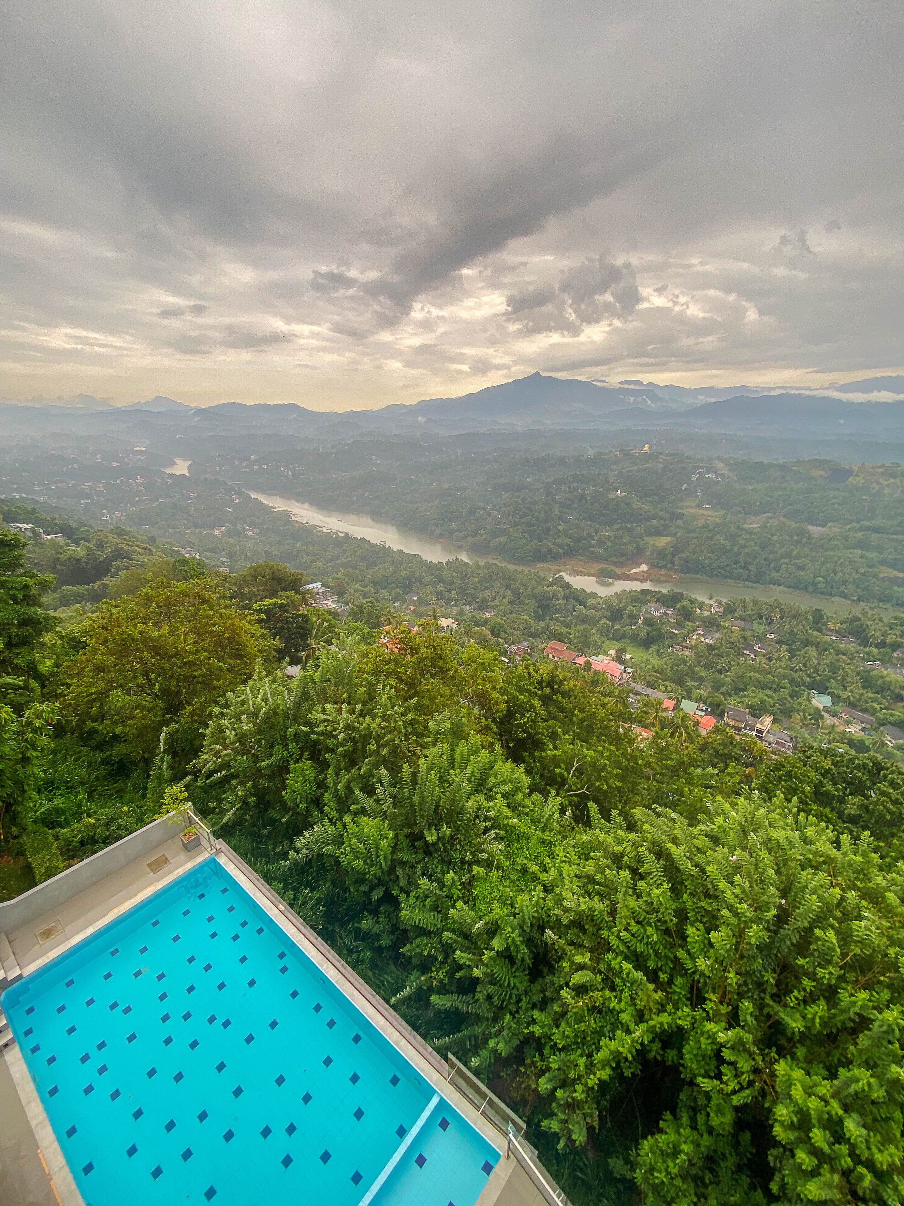 Une piscine avec vue sur une rivière et des montagnes en arrière-plan.