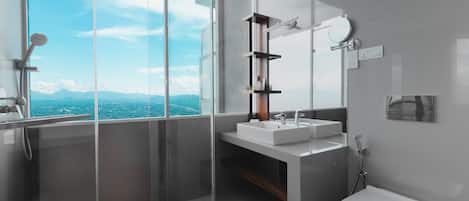 A modern bathroom with a glass shower enclosure, a white sink, and a toilet.