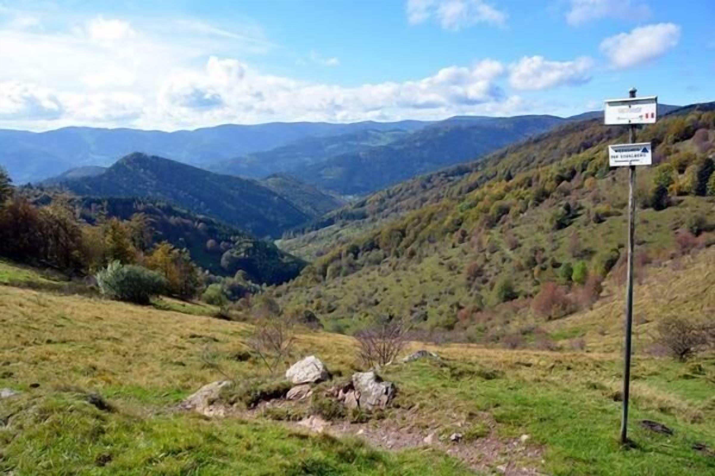 A mountainous landscape with a signpost indicating a viewpoint.