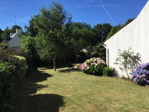 A well-maintained garden with a variety of flowering plants and a lawn.