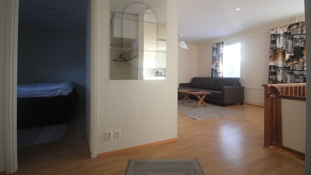 A room with a bed, a sofa, a small table, and a mirror. - Jääskän Loma Ratatie Apartments Kauhava (Kauhava)