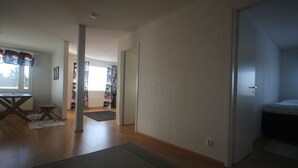 A spacious room with a large window, a wooden floor, and a bed. - Jääskän Loma Ratatie Apartments Kauhava (Kauhava)