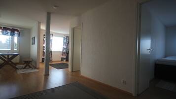 Stylish room with a large area rug, hardwood flooring, and a window with curtains.