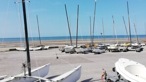 Ein Strand mit mehreren Segelbooten, die im Sand vor Anker liegen.