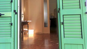 A room with a green door, a hanging light fixture, and a visible hallway. - Detached house, near the coast, in a quiet area on the outskirts of BASTIA (Ville-Di-Pietrabugno)
