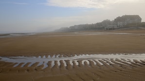A beach with footprints in the sand and buildings in the background. - Beautiful renovated apartment - Walking distance to town and sea - Private parking (Cabourg)