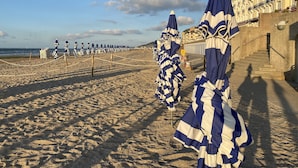 A beach with rows of striped umbrellas and a building with balconies. - Beautiful renovated apartment - Walking distance to town and sea - Private parking (Cabourg)