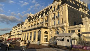 A historic building with a grand facade, multiple balconies, and a prominent entrance. - Beautiful renovated apartment - Walking distance to town and sea - Private parking (Cabourg)