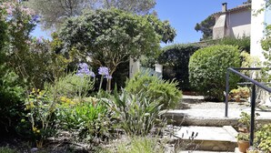 A garden with stone steps leading up to a house.
