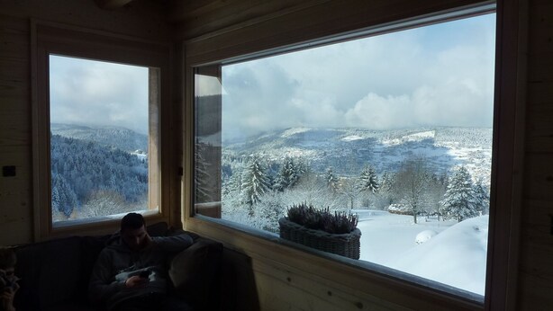 A room with large windows offering a snowy mountain view.