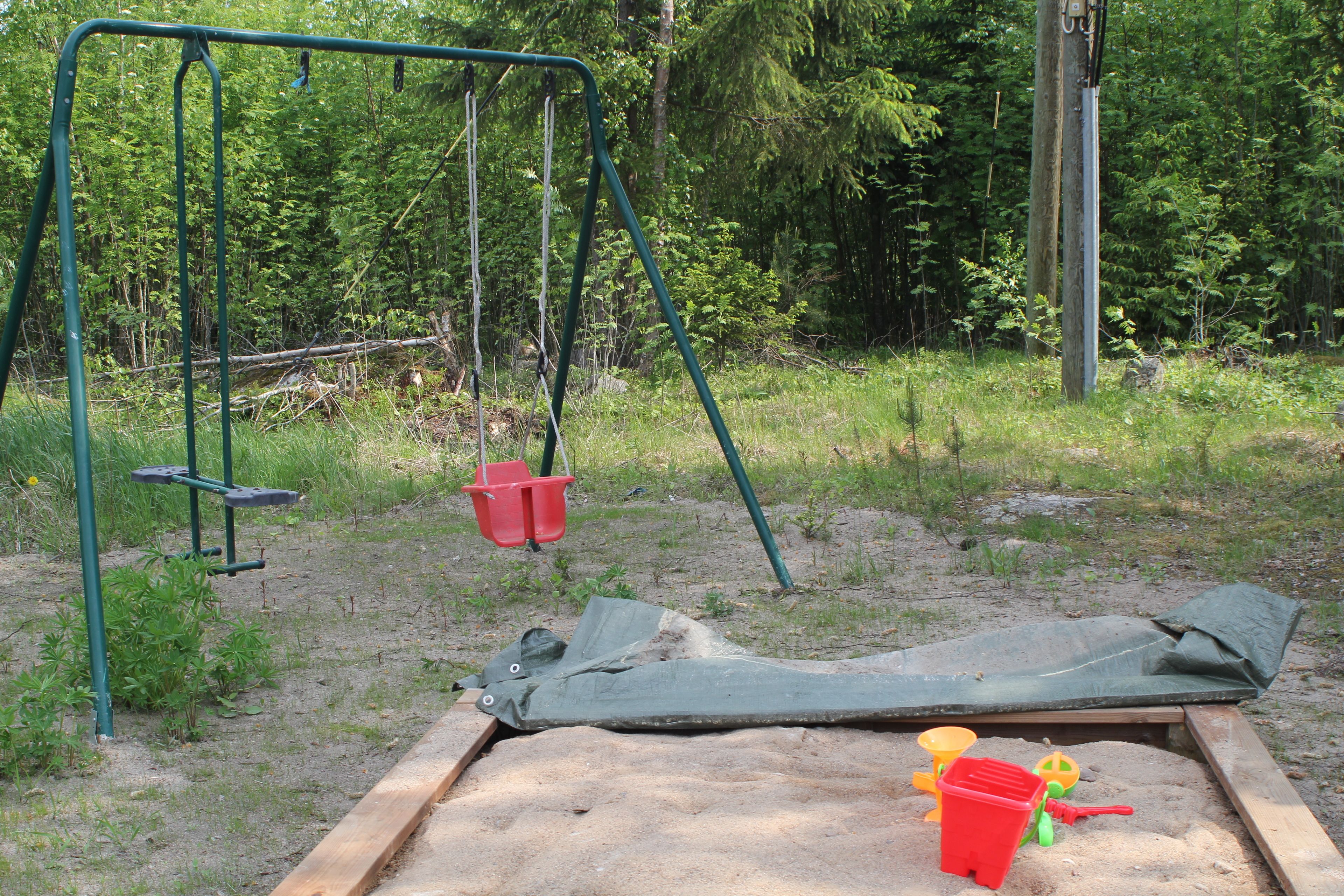 A playground with a swing set and sand play area.