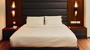 A modern bedroom with a large bed, wooden headboard, and bedside lamps. - Hyde Park (Ernad)