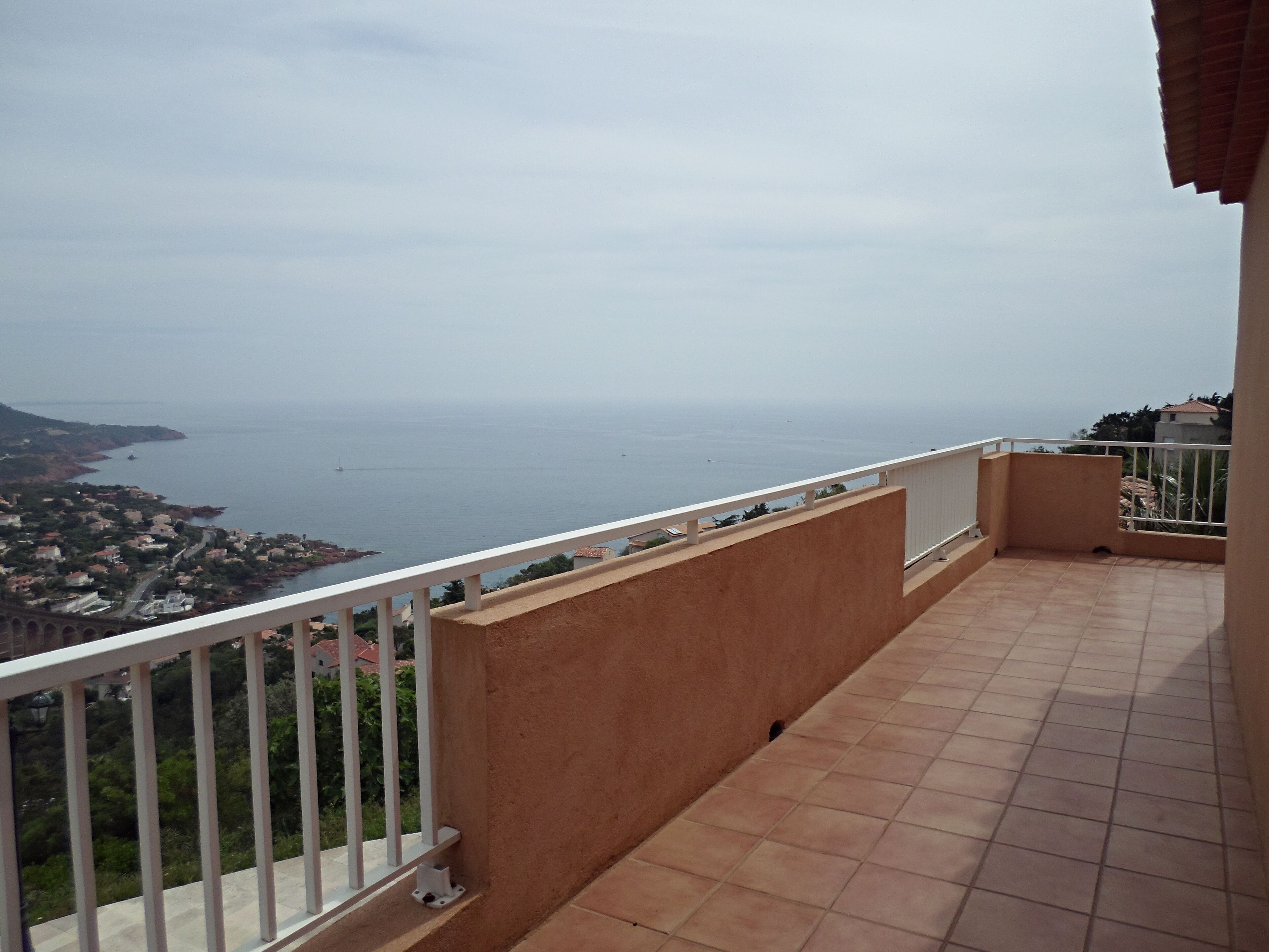 Un balcon avec vue sur la mer et sur une ville côtière.