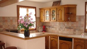 A kitchen with wooden cabinets, a central island with stools, a coffee maker, and a dishwasher. - Facing the sea and the Estérel massif, Antheor, town of Saint Raphaël  (Saint-Raphaël)