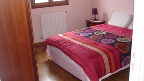 A bedroom with a wooden floor, a bed with a patterned quilt, a bedside table with a lamp, and a window with blinds. - Facing the sea and the Estérel massif, Antheor, town of Saint Raphaël  (Saint-Raphaël)