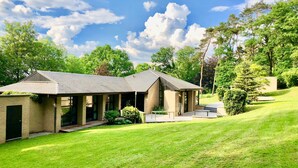 A modern two-story house with a covered patio and a well-maintained lawn.