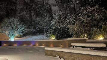 A snow-covered outdoor area with steps and brick walls, illuminated by ambient lighting.