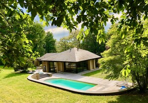 A modern house with a swimming pool, surrounded by lush greenery and a covered patio. - Villa des Templiers - 20 minutes from Brussels Airport - Sleeps 8 to 15 - (Wavre)