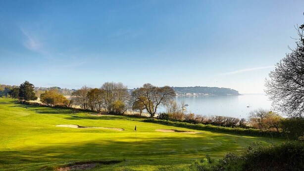 A golf course with a flagstick, sand bunkers, and a view of the sea. - Village house Scandinavian charm (Carantec)