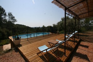 A wooden deck with a pool, lounge chairs, and a pergola. - Nature and calm are reaching out to you (Cotignac)
