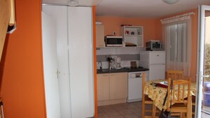 Cocina compacta con comedor, que incluye microondas, tostadora y refrigerador.