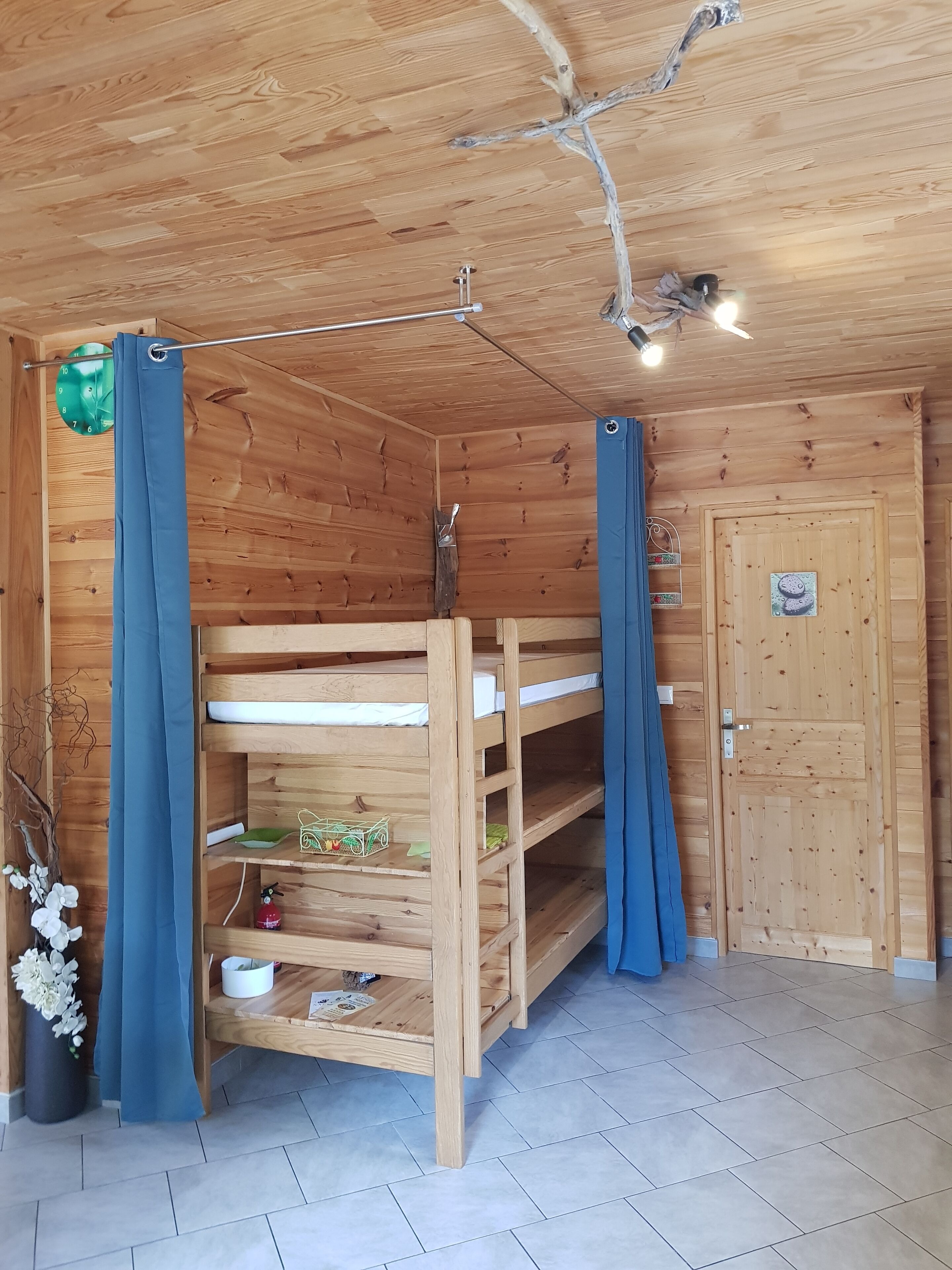 Een houten hut met stapelbedden, een klok en een deur.
