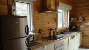 A compact kitchen with a refrigerator, microwave, sink, and oven. - In Mimizan-plage sud, small wooden house facing the forest, 2km from the ocean  (Mimizan)