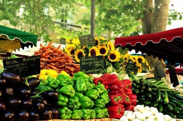 A market stall with fresh vegetables like eggplants, bell peppers, and carrots, with price tags visible. - Mas 8 people at the foot of MonT Ventoux 2 ??steps from the Alpilles & Luberon (Sarrians)