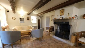 Una sala de estar acogedora con chimenea, un sofá y dos sillones.