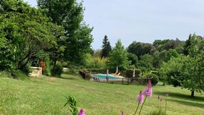 A grassy area with a swimming pool, surrounded by trees and a fence. - Comfortable cottage in a wooded area by the pool near Sarlat (Calviac-En-Périgord)