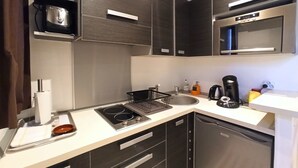 Une cuisine moderne équipée d’une cuisinière, d’un four à micro-ondes et d’un lave-vaisselle intégrés.