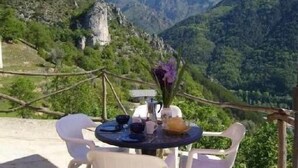 A table set outdoors with chairs, surrounded by a mountainous landscape.