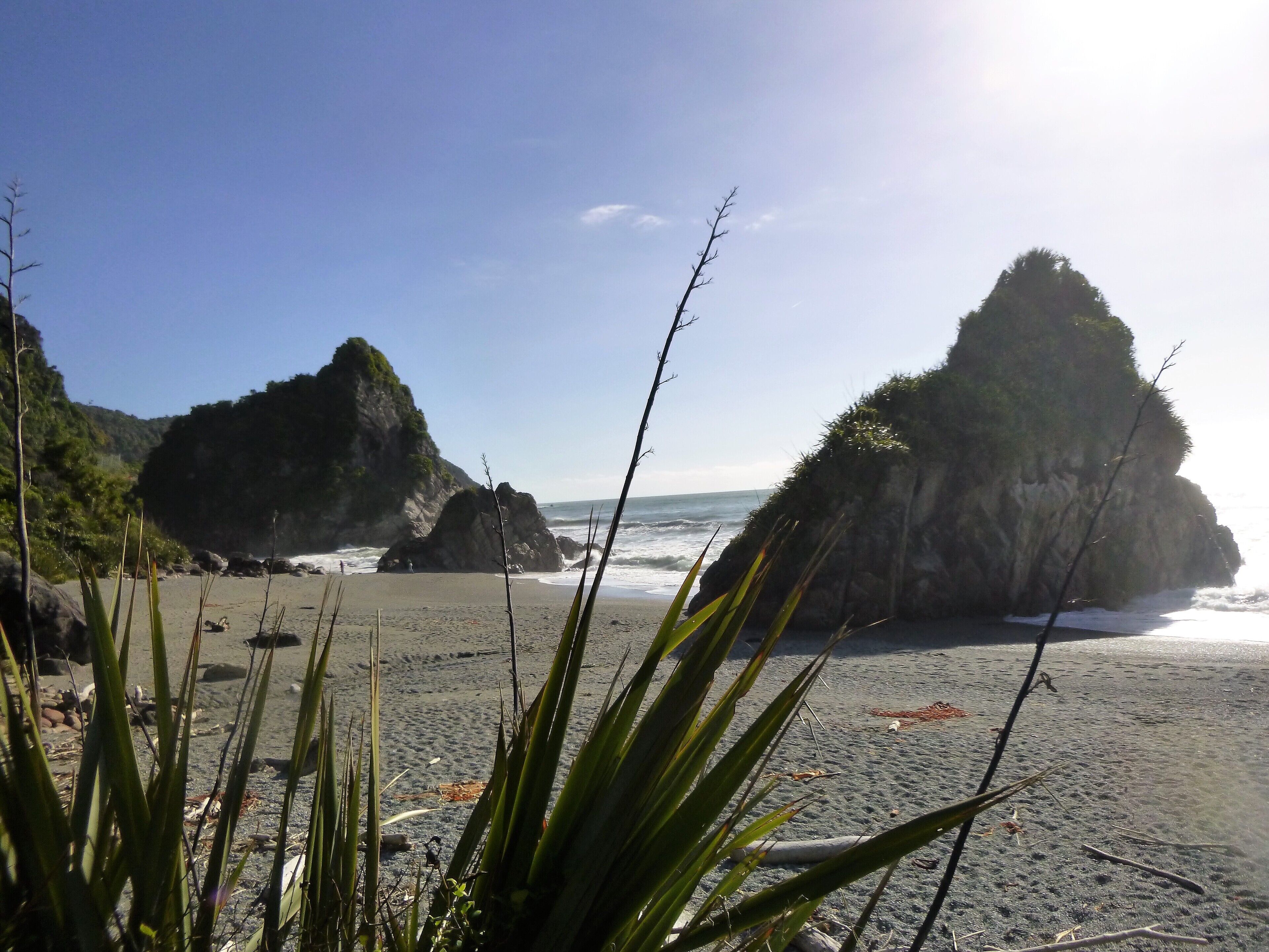 A beach with rocky formations and clear skies.