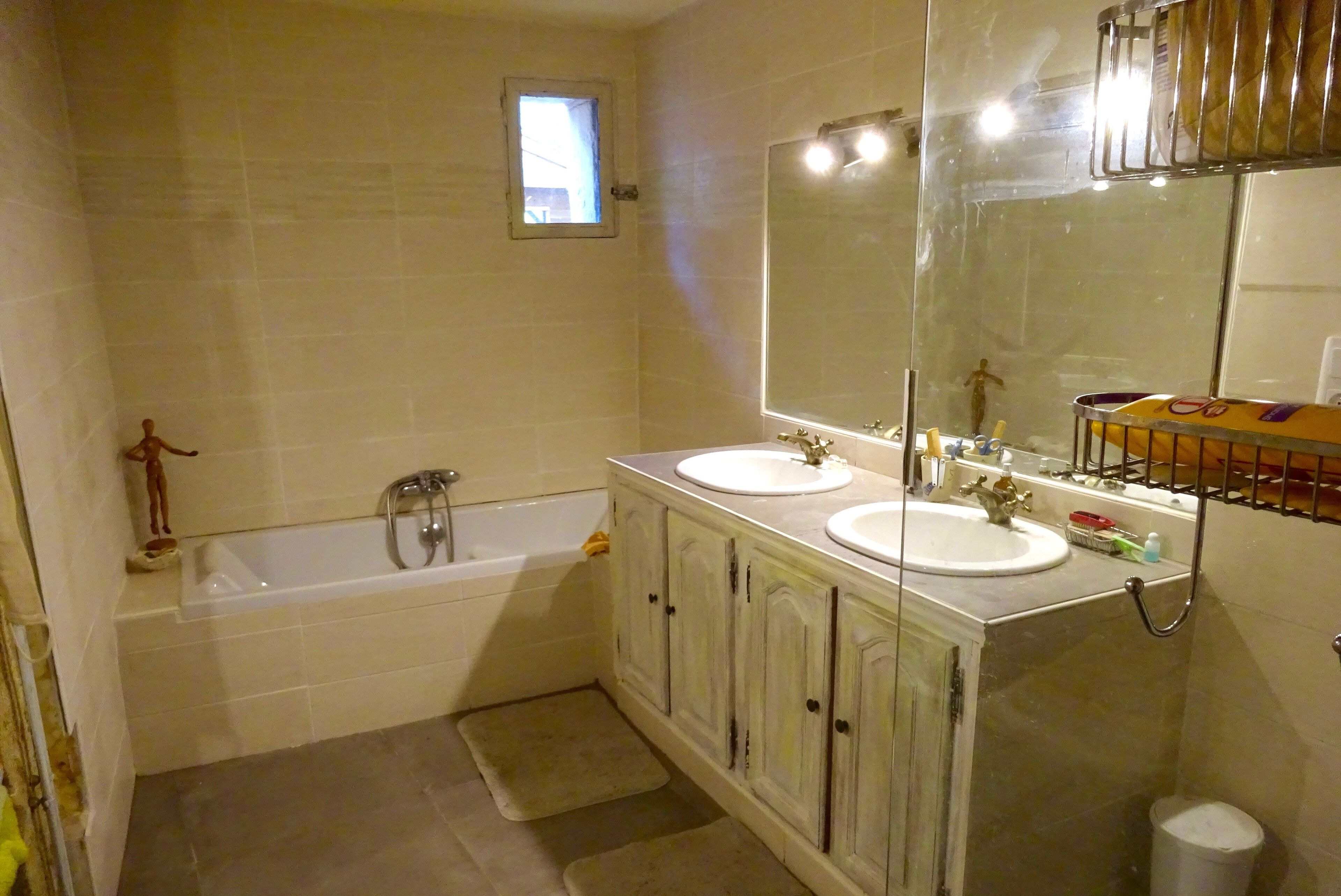 A bathroom with two sinks, a bathtub, and a large mirror.