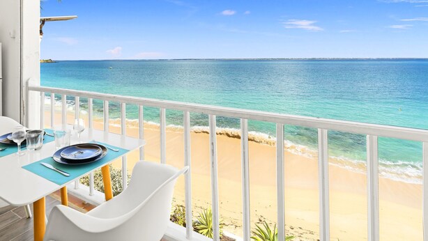 A balcony with a view of a beach and ocean.