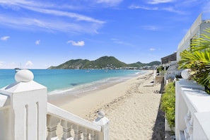 A beach with a clear view of the ocean and a mountainous backdrop.