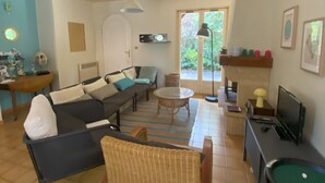 Una sala de estar con sofá, sillón y mesa de billar.