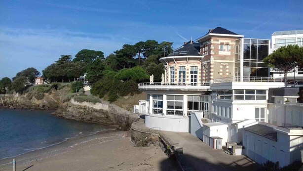 A coastal building with a balcony overlooking the beach, a stone retaining wall, and a view of the sea. - Fully renovated house, all comforts, near beach, free wi-fi access.  (La Bernerie-En-Retz)