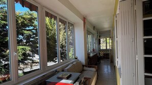 A laundry area with a washing machine, a bench, and a window with a view of trees.