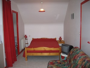 Une petite chambre agréable, dotée d’un lit simple, d’une télévision et d’un canapé.