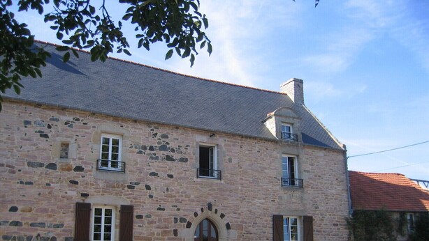 A stone building with a central entrance, windows, and a sloped roof. - Countryside apartment near the sea (sleeps 2 to 4) (Erquy)