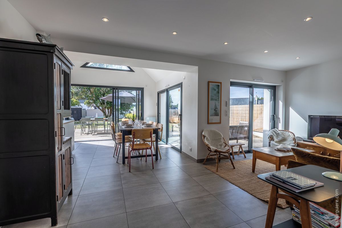 A modern interior with a dining area, a kitchen, and a living space with a fireplace.