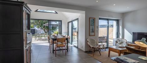 A modern interior with a dining area, a kitchen, and a living space with a fireplace.