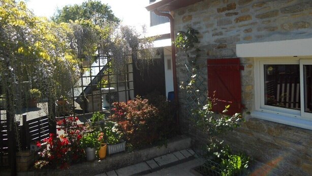 A stone building with a red window shutter, a staircase, and potted plants. - Relaxing holiday / wifi (Concarneau)