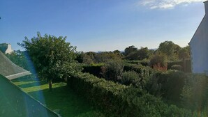 A garden with various plants and trees, a clear blue sky, and a building in the background. - Seaside house in South Finistère, 300m from the beach. (Combrit)