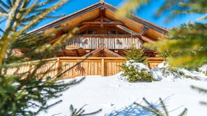 A wooden chalet with a balcony, surrounded by snow and pine trees. - La fuste des Chevaux, log cabin, kota-sauna, Nordic bath, 6 people (La Bresse)