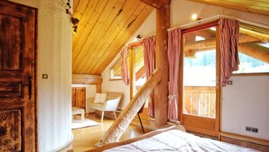 A wooden interior with a bed, a chair, and a window with checkered curtains. - La fuste des Chevaux, log cabin, kota-sauna, Nordic bath, 6 people (La Bresse)