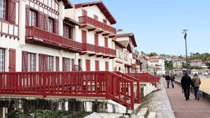 A traditional building with a red balcony and a stone pathway.