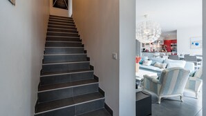 Een moderne trap met donkere treden die leidt naar een goed verlichte ruimte.