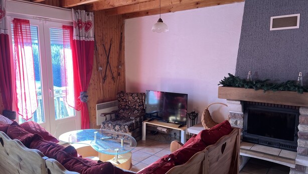 A cozy living room with a fireplace, wooden furniture, and a television.